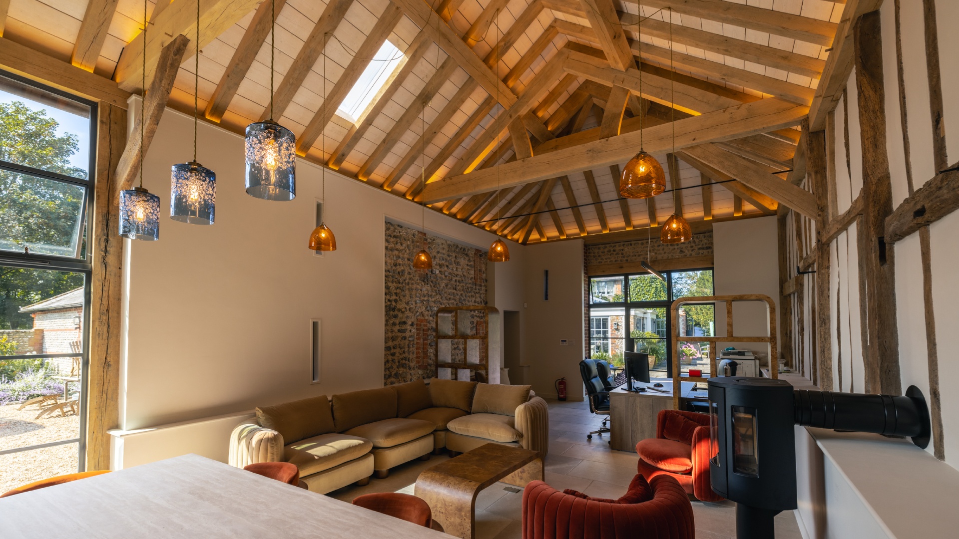 Oak-framed barn interior with exposed pitched roof beams and pendant lighting